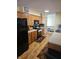 Well-equipped kitchen with wood cabinets, black appliances and light hardwood flooring at 5816 Coppock Ln, Indianapolis, IN 46221