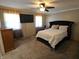Main bedroom with a ceiling fan, dresser and a mounted TV at 5816 Coppock Ln, Indianapolis, IN 46221