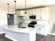 Modern kitchen featuring a marble island, stainless steel appliances, white cabinets and stylish pendant lighting at 618 Firefly Ct, Greenfield, IN 46140