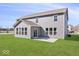 A spacious backyard featuring a patio, level lot, and home with gray siding, windows, and a sunroom at 6723 Collisi Pl, Brownsburg, IN 46112
