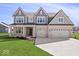 Beautiful two-story home featuring a three-car garage, light brick, grey trim, and a well-manicured lawn at 6723 Collisi Pl, Brownsburg, IN 46112