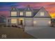 Beautiful two-story home with brick facade and attached three-car garage at sunset at 6723 Collisi Pl, Brownsburg, IN 46112