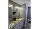 A full bathroom is equipped with double sinks, granite countertops, and updated lighting fixtures at 686 N Sobota Way, Trafalgar, IN 46181
