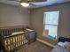 Cozy Bedroom featuring a crib and a large window at 686 N Sobota Way, Trafalgar, IN 46181