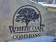A stone monument sign for White Oak Commons with winter snow on the ground at 686 N Sobota Way, Trafalgar, IN 46181