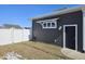 Gray siding with a white window and a black side entrance door to the attached garage at 686 N Sobota Way, Trafalgar, IN 46181