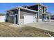 Attached two-car garage featuring gray siding, white trim, and a modern white garage door at 686 N Sobota Way, Trafalgar, IN 46181
