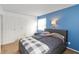 A well-lit bedroom features a gray bed with storage, set against a blue accent wall and white trim at 6907 Buick Dr, Indianapolis, IN 46214