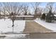 Charming ranch-style home featuring a spacious driveway and well-maintained front yard covered in a blanket of fresh snow at 6907 Buick Dr, Indianapolis, IN 46214