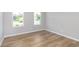 Bright bedroom featuring wood-look flooring, white trim, and large windows providing natural light at 7026 Barrett Dr, Brownsburg, IN 46075