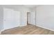 Spacious bedroom with closet and door, featuring modern light gray paint and wood-look flooring at 7026 Barrett Dr, Brownsburg, IN 46075