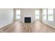 Inviting living room showcasing a fireplace, large windows, and wood-look floors at 7026 Barrett Dr, Brownsburg, IN 46075