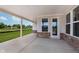 Covered back patio featuring a concrete floor, brick accents, and views of the green backyard at 7026 Barrett Dr, Brownsburg, IN 46075