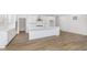 Modern white kitchen with ample cabinet space, stainless steel hood, island, and wood-look flooring at 7038 Barrett Dr, Brownsburg, IN 46112