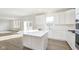 Well-lit kitchen with white cabinets, stainless appliances, an island, and wood-look floors at 7197 Barrett Dr, Brownsburg, IN 46112