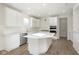 Modern kitchen boasts white cabinetry, stainless appliances, tile backsplash, and center island at 7197 Barrett Dr, Brownsburg, IN 46112