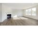 Spacious living room with wood-look floors, white walls, fireplace, and ample natural light at 7197 Barrett Dr, Brownsburg, IN 46112