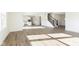 Open concept living space with wood-look floors, staircase, and a view of the kitchen at 7197 Barrett Dr, Brownsburg, IN 46112