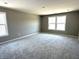 Serene bedroom featuring neutral walls, plush carpet, and large windows providing natural light at 750 Oakleaf Dr, Greenfield, IN 46140
