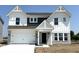 Charming two-story home featuring white siding, dark accents, a two-car garage, and manicured front yard at 750 Oakleaf Dr, Greenfield, IN 46140