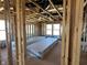 View of a home's exposed wood frame interior displaying studs, insulation, wiring, and stacked drywall sheets at 750 Oakleaf Dr, Greenfield, IN 46140