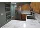 Modern kitchen with stainless steel appliances, wood cabinets, and marble countertops at 8148 Shores Edge Way, Indianapolis, IN 46237