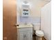 Bathroom features white cabinets and toilet, patterned wallpaper and wood-look flooring at 11131 N State Road 9, Fountaintown, IN 46130