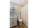Bathroom features white cabinets and toilet, patterned wallpaper and wood-look flooring at 11131 N State Road 9, Fountaintown, IN 46130