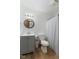 Bathroom features white cabinets and toilet, wood-look flooring and a round mirror at 11131 N State Road 9, Fountaintown, IN 46130