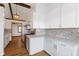 Updated eat-in kitchen showcasing white cabinets, gray backsplash, and modern countertops at 11131 N State Road 9, Fountaintown, IN 46130
