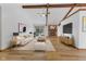 A cozy living room featuring a brick fireplace, wooden beams, and neutral-toned furnishings at 11131 N State Road 9, Fountaintown, IN 46130