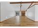 An open living room with wood beam ceiling, brick fireplace, and sliding glass doors at 11131 N State Road 9, Fountaintown, IN 46130