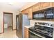 This kitchen features stainless appliances, including a refrigerator, microwave, and a black cooktop oven at 120 Saratoga Way, Anderson, IN 46013