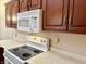 This well-equipped kitchen features wooden cabinets, an electric range, and a microwave at 1336 Country Creek Cir, Shelbyville, IN 46176