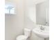 White bathroom features a pedestal sink, toilet, and window for natural light at 19763 Atwater Ave, Sheridan, IN 46069