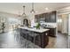 Open kitchen with dark cabinets, large island with seating and pendant lighting at 19763 Atwater Ave, Sheridan, IN 46069