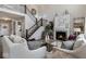 Elegant living room with a fireplace, staircase with iron railings, and neutral color palette at 19763 Atwater Ave, Sheridan, IN 46069