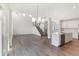 Open concept living area with hardwood floors, staircase with iron railings, and modern kitchen at 19763 Atwater Ave, Sheridan, IN 46069