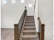 Elegant staircase with wood railings and plush carpeting leading to the upper level of the home at 19763 Atwater Ave, Sheridan, IN 46069