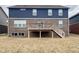 Backyard view of a two-story home with a spacious wooden deck accessible by stairs at 1986 Mccormick Dr, Greenwood, IN 46143