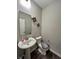 Elegant half bathroom features a pedestal sink, decorative mirror, and neutral walls at 1986 Mccormick Dr, Greenwood, IN 46143