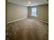 A neutral bedroom features plush carpeting and a bright window for a cozy and inviting space at 1986 Mccormick Dr, Greenwood, IN 46143