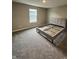 Bright bedroom features neutral walls, plush carpet, and a stylish gray bed frame with clean lines at 1986 Mccormick Dr, Greenwood, IN 46143