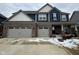 Charming two-story home featuring a two-car garage, brick facade, and blue siding at 1986 Mccormick Dr, Greenwood, IN 46143
