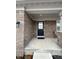 Cozy front porch with brick columns, seating area, and a stylish black front door at 1986 Mccormick Dr, Greenwood, IN 46143