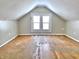 Bright attic with double window, white walls and ceiling, and hardwood floors at 210 S West St, Paragon, IN 46166