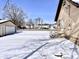 View of a home's backyard with a detached garage, snow covered yard and stairs leading to the door at 210 S West St, Paragon, IN 46166