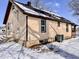 Side view of a home with tan siding, dark brown trim, and snow covered roof and yard at 210 S West St, Paragon, IN 46166