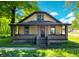 Charming two-story home with brick and siding, complimented by an inviting front porch and lush greenery at 210 S West St, Paragon, IN 46166