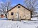 Front exterior of a tan house with dark brown trim, steps leading up to the front door, and a snow covered yard at 210 S West St, Paragon, IN 46166